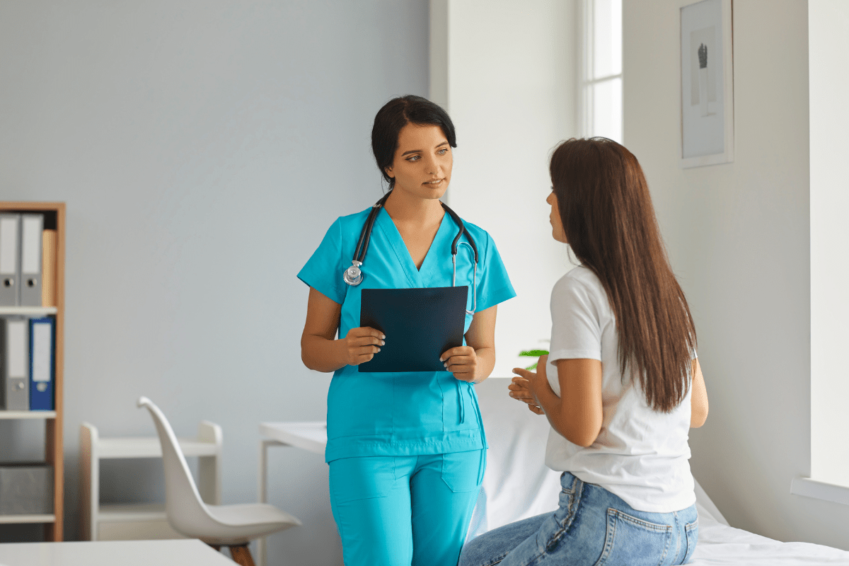Nurse speaking to woman in clinic