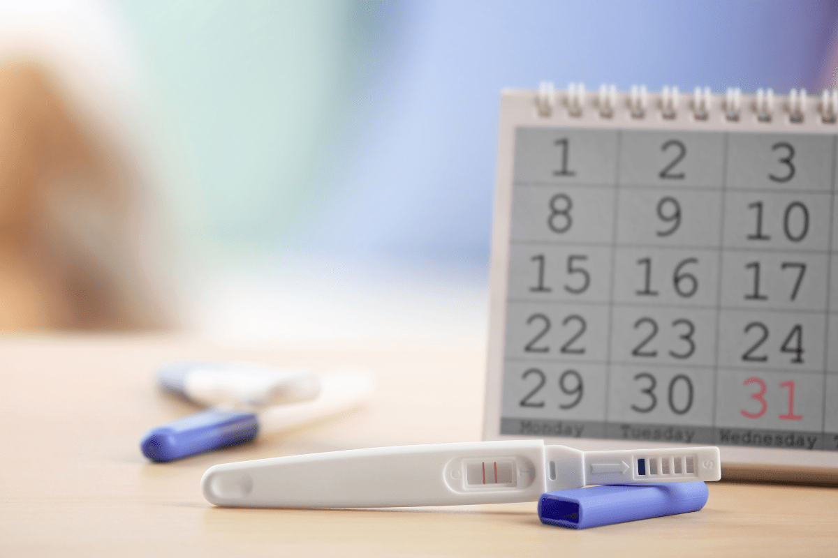 Calendar with pregnancy test in front of it